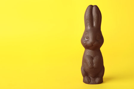 Chocolate bunny on yellow background, space for text. Easter celebrationの写真素材