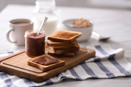 Delicious breakfast with toasts and jam on table in kitchenの写真素材