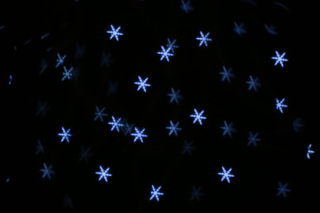 White snowflake shaped glitter on black backgroundの写真素材