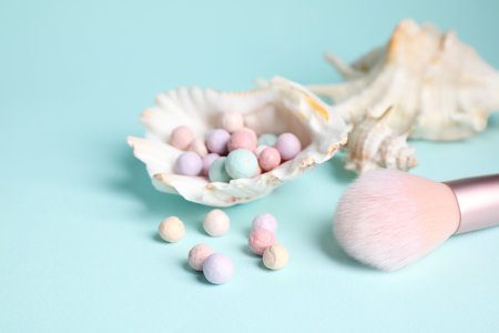 Powder balls, make up brush and sea shell on light blue background, closeupの写真素材