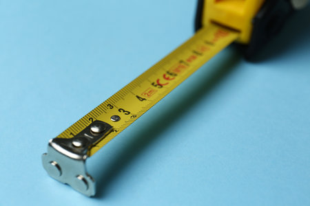 Tape measure on light blue background, closeup. construction toolの写真素材