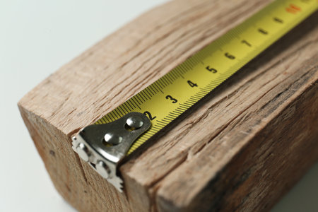 Tape measure on timber strip, closeup. construction toolの写真素材