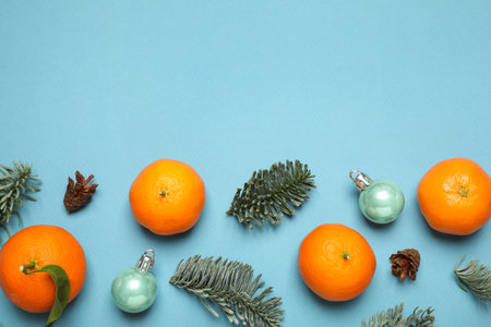 Composition with Christmas balls and tangerines on light blue background, flat lay. Space for textの写真素材