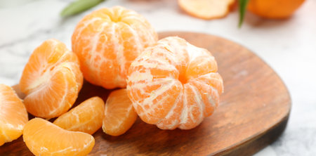 Fresh peeled tangerines on wooden board, closeupの写真素材