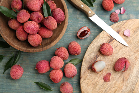 Fresh ripe lychee fruits and knife on wooden table, flat layの写真素材