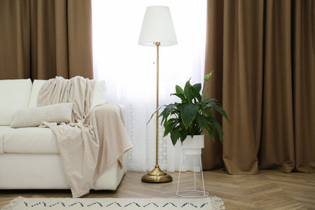 Sofa and window with brown curtains in simple room interiorの写真素材