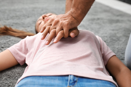 Man performing CPR on unconscious young woman indoors, closeup. First aidの写真素材