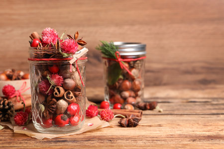 Aromatic potpourri in glass jar on wooden table. Space for textの写真素材