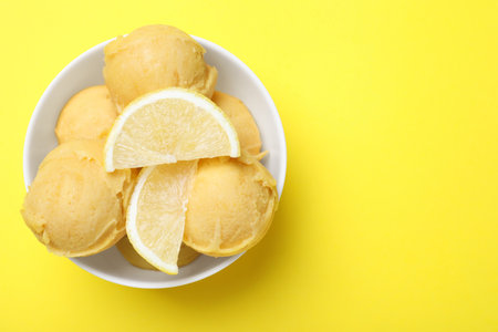 Delicious lemon ice cream on yellow background, top view. Space for textの写真素材