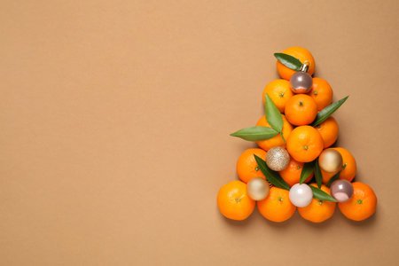 Christmas tree shape made of tangerines on light brown background, flat lay. Space for textの写真素材