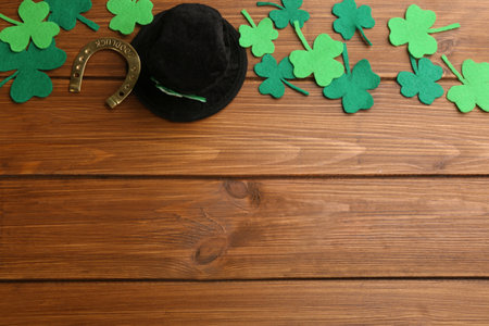 Flat lay composition with leprechaun hat on wooden table, space for text. St Patrick's Day...