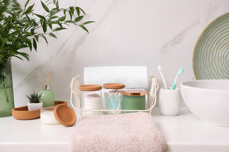 Personal hygiene products on table near white wall in bathroom