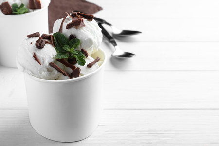 Yummy ice cream with chocolate served on white wooden table. Space for textの写真素材