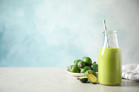 Fresh feijoa smoothie and fresh fruits on gray table, space for textの写真素材