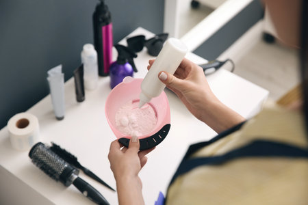 Professional hairdresser preparing dye for hair coloring in beauty salon, closeupの写真素材