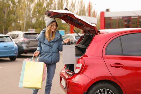 Woman with shopping bags near her car outdoorsの写真素材
