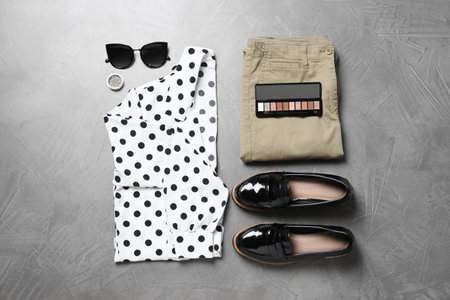 Women's clothes and makeup products on gray background, flat layの写真素材
