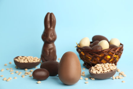 Sweet chocolate eggs and bunny on light blue backgroundの写真素材