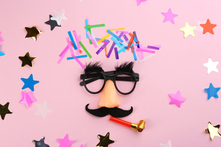 Clown face, confetti and party horn on pink background, flat layの写真素材
