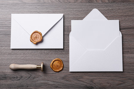 Envelopes with wax seal and stamp on wooden table, flat layの写真素材