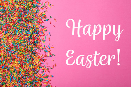 Text Happy Easter and colorful sprinkles on pink background, flat lay. Confectionery decorの写真素材
