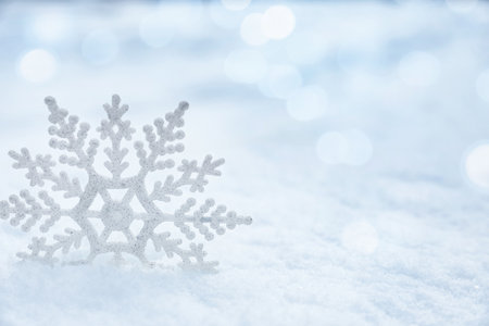 Beautiful decorative snowflake on white snow. Space for textの写真素材