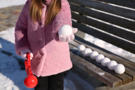 Little girl playing with snowball maker outdoors, closeupの写真素材
