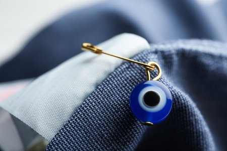 Evil eye safety pin on clothing, closeupの写真素材