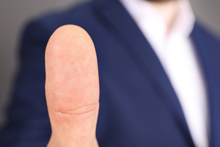 Man in office suit scanning fingerprint, closeupの写真素材