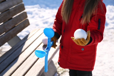 Little girl playing with snowball maker outdoors, closeupの写真素材
