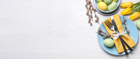 Festive Easter table setting with eggs on white wooden background, flat lay. Space for text