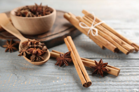 Aromatic cinnamon sticks and anise on gray wooden table