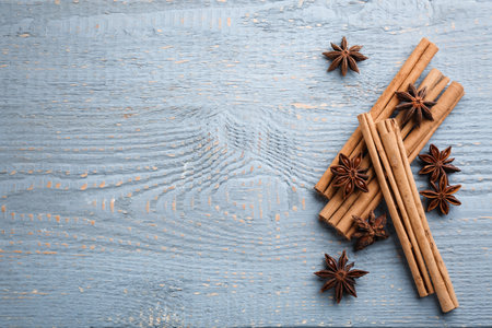 Aromatic cinnamon sticks and anise on gray wooden table, flat lay. Space for textの写真素材