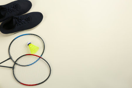 Rackets, sneakers and shuttlecock on beige background, flat lay with space for text. badminton equipmentの写真素材