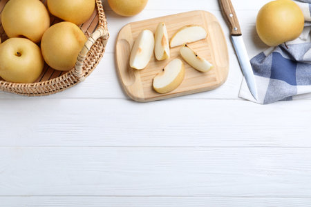 Cut and whole apple pears on white wooden table, flat lay. Space for textの写真素材