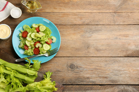 Delicious fresh celery salad served on wooden table, flat lay. Space for textの写真素材