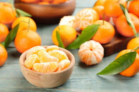 Fresh tangerine slices on blue wooden tableの写真素材