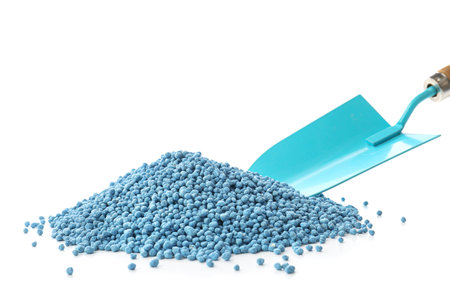 Pile of granular mineral fertilizer with shovel on white backgroundの写真素材