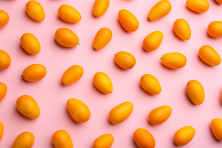 Fresh ripe kumquats on pink background, flat layの写真素材