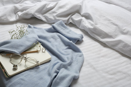 Composition with soft cashmere sweater on bed at home, space for textの写真素材