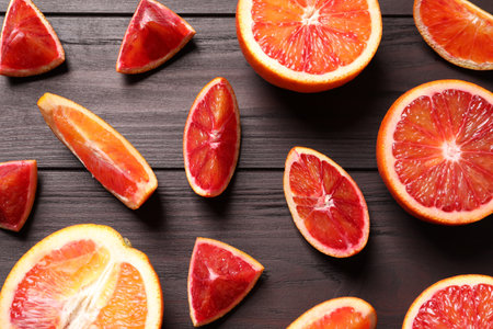 Cut fresh ripe red oranges on wooden table, flat layの写真素材