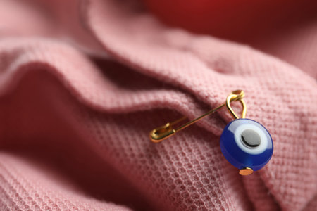 Evil eye safety pin on clothing, closeupの写真素材