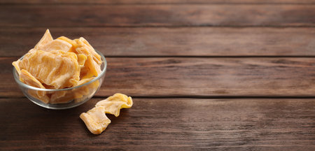 Delicious dried jackfruit slices on wooden table. Space for textの写真素材