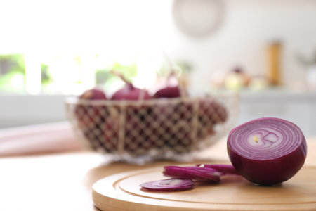 Cut red onion on wooden table in kitchenの写真素材