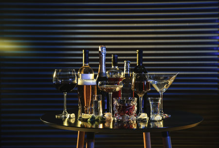 Many different alcoholic drinks on table against dark background