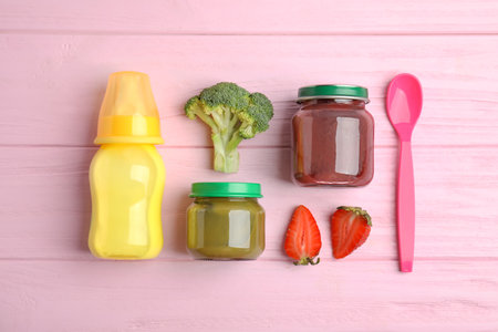 Flat lay composition with healthy baby food and ingredients on pink wooden tableの写真素材