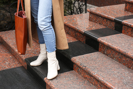 Woman in stylish leather shoes with bag on stairs outdoors, closeupの写真素材