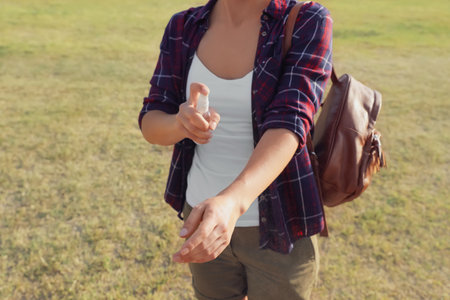 Woman applying insect repellent onto arm outdoors, closeupの写真素材