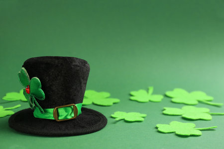 Leprechaun's hat and decorative clover leaves on green background. St. Patrick's day celebrationの写真素材