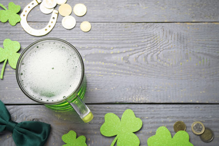 Green beer, gold and St Patrick's Day decor on gray wooden table, flat lay. Space for textの写真素材